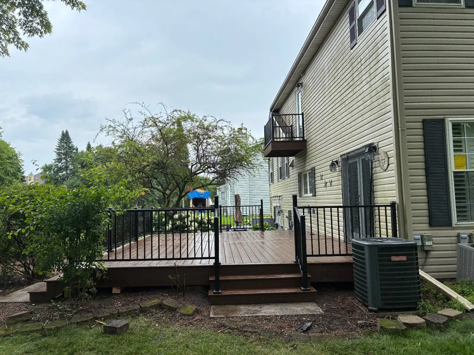 The finished Bloomingdale deck from the yard, one step down to the lawn, air conditioner beside it