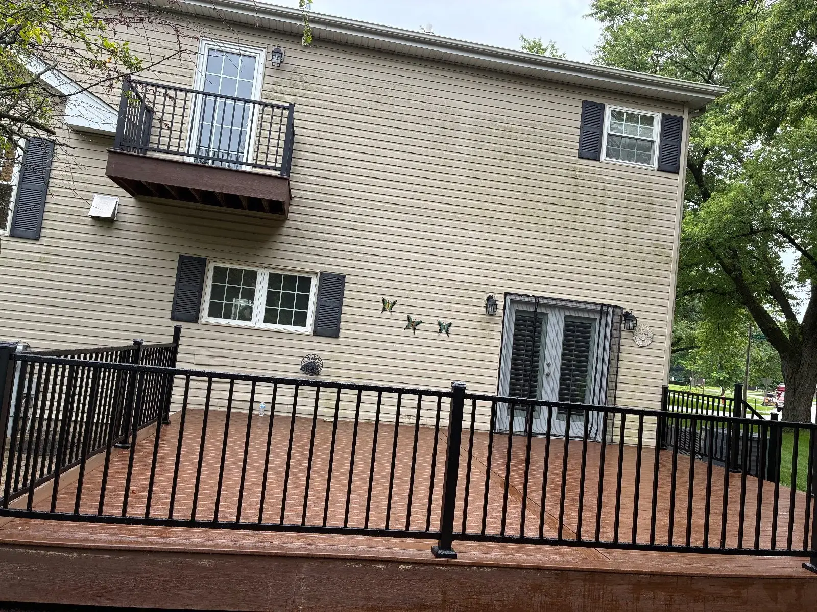 Finished brown composite deck with black aluminum railing on a two-storey Bloomingdale home