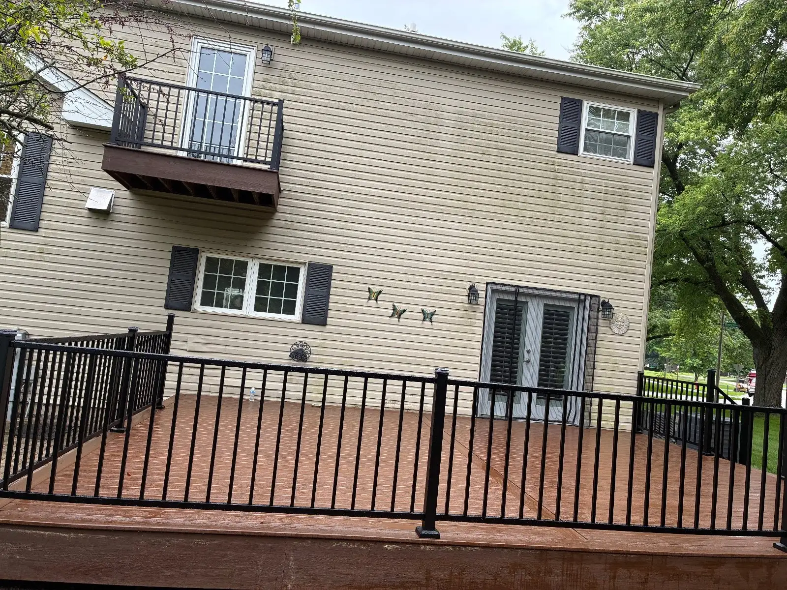 Finished brown composite deck with black aluminum railing on a two-storey Bloomingdale home