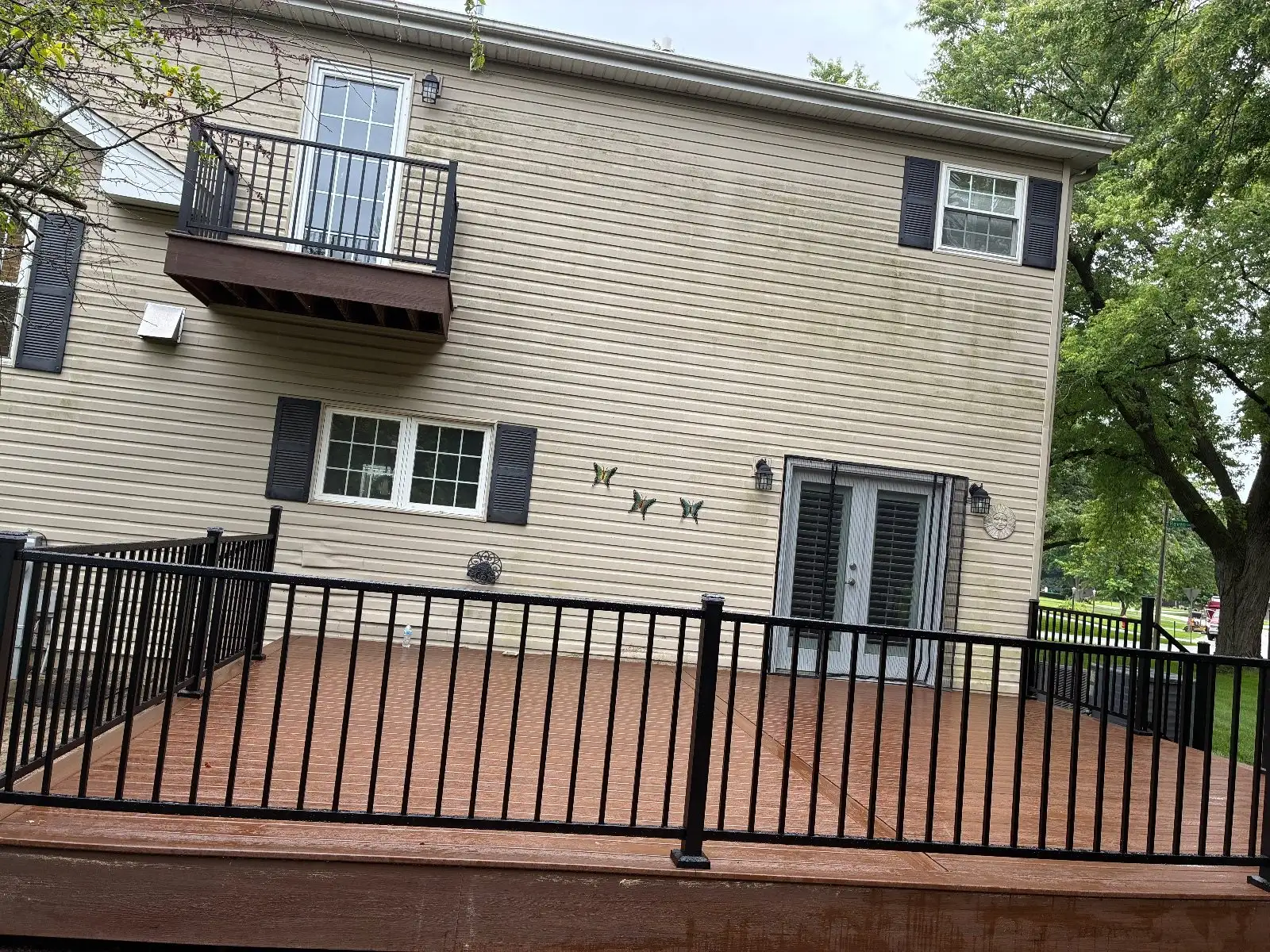 Finished brown composite deck with black aluminum railing on a two-storey Bloomingdale home