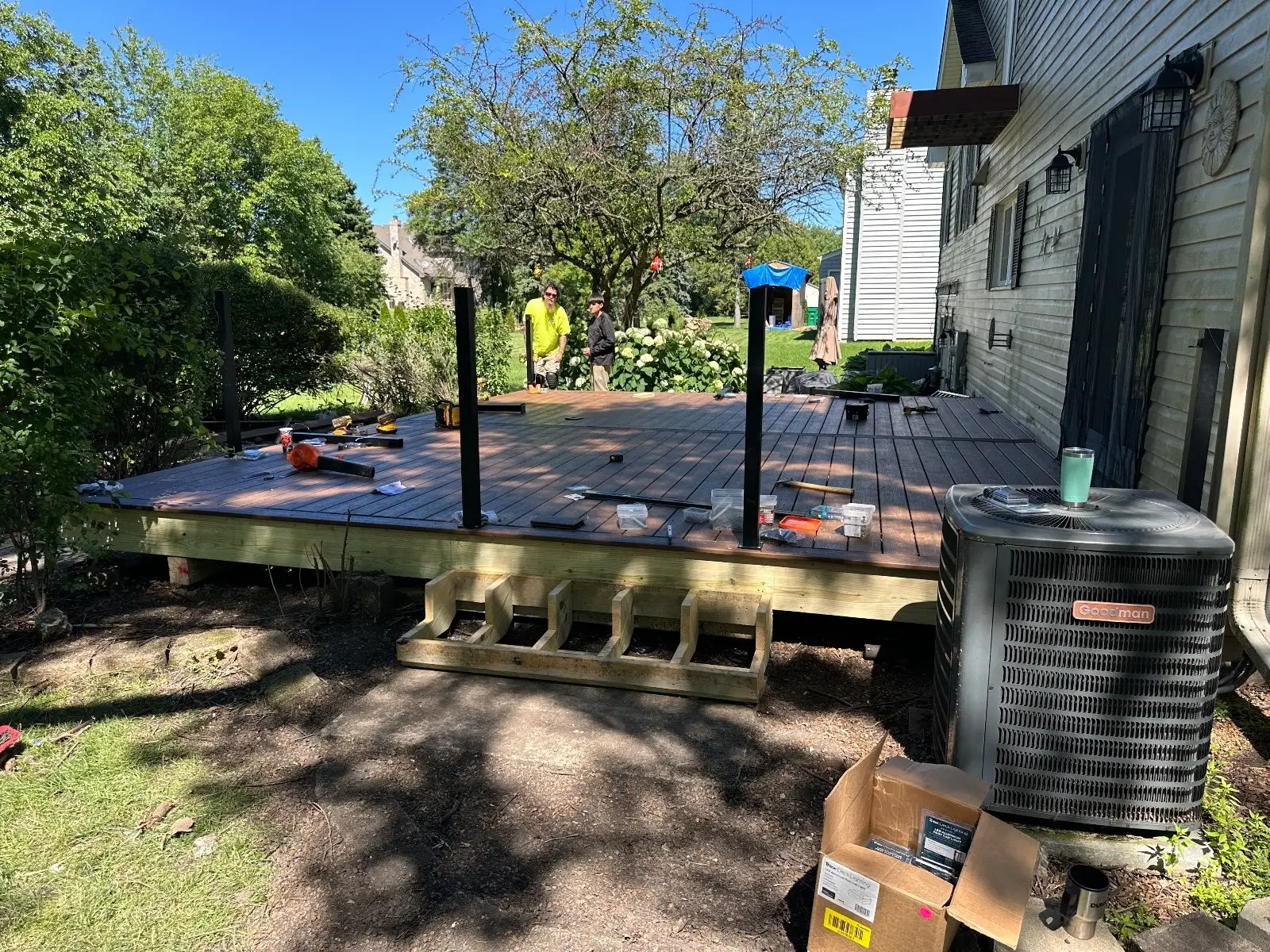 Brown composite boards going down over the new frame, black railing posts already set