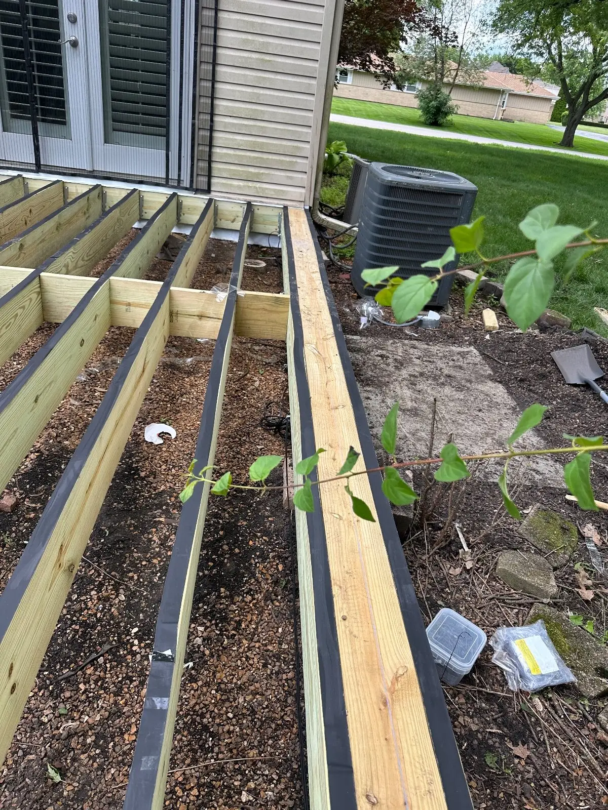 New pressure-treated joists with black joist tape at the door of a Bloomingdale home