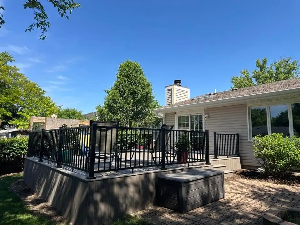 Low grey composite deck with black aluminum railings and planters along the edge