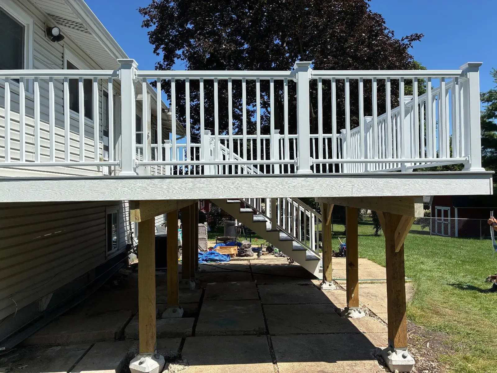 Finished elevated composite deck with white railing on the back of a Hoffman Estates raised ranch