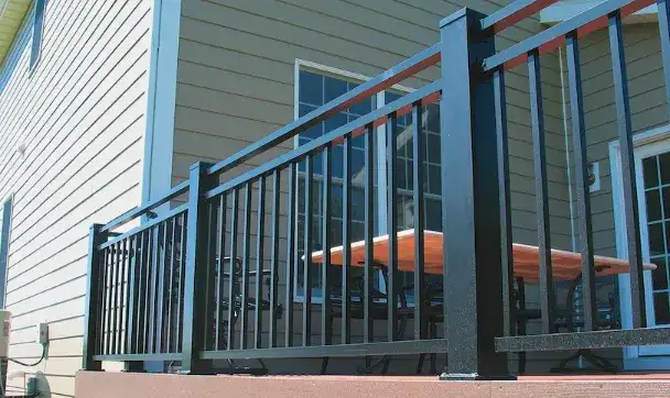 Close-up of a black aluminum railing with horizontal cable infill on a grey composite deck