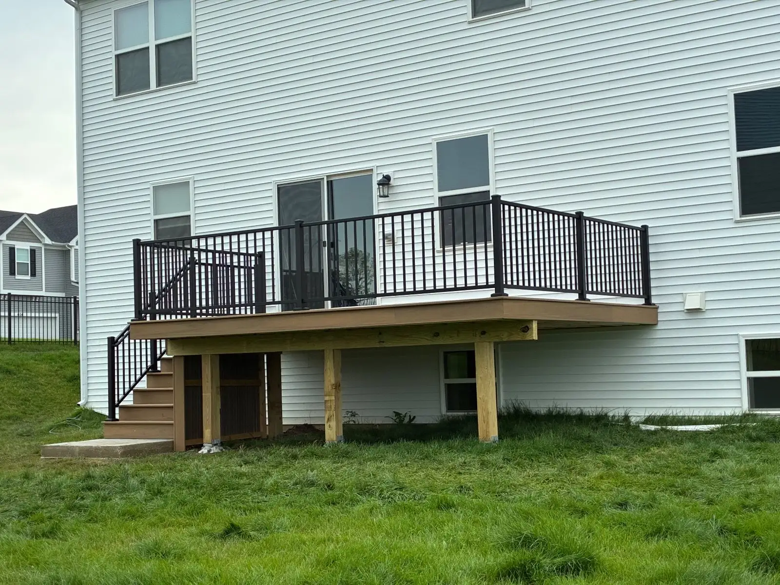 The stair run and 6x6 posts under the tan composite deck with black railing