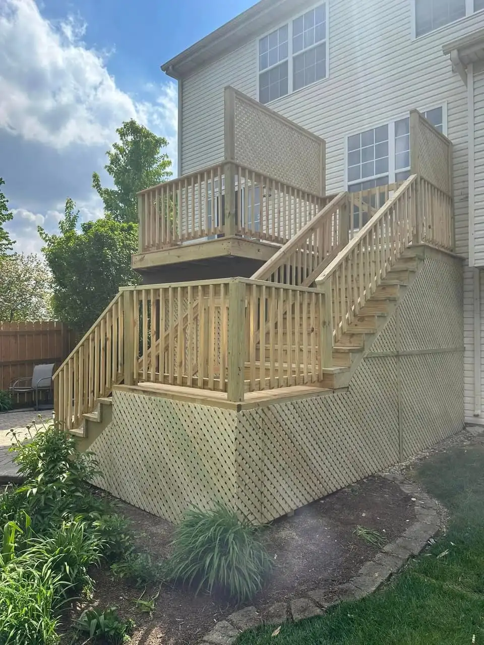 Pressure-treated wood deck with a full staircase and lattice skirting along the base